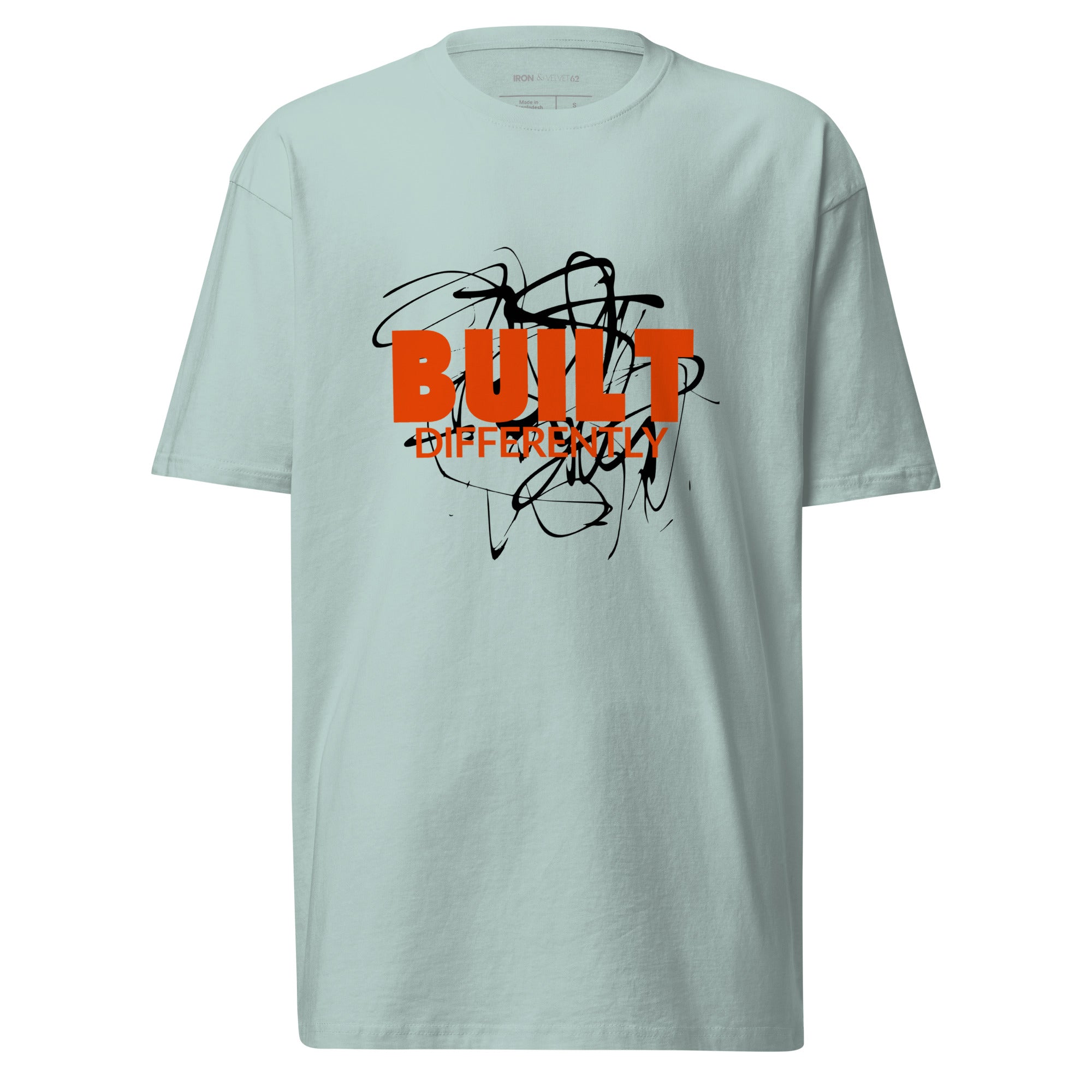 mens agave color tshirt displayed on a white background with bold orange built differently text and abstract graphic design across the chest modern statement streetwear piece by iron and velvet 62