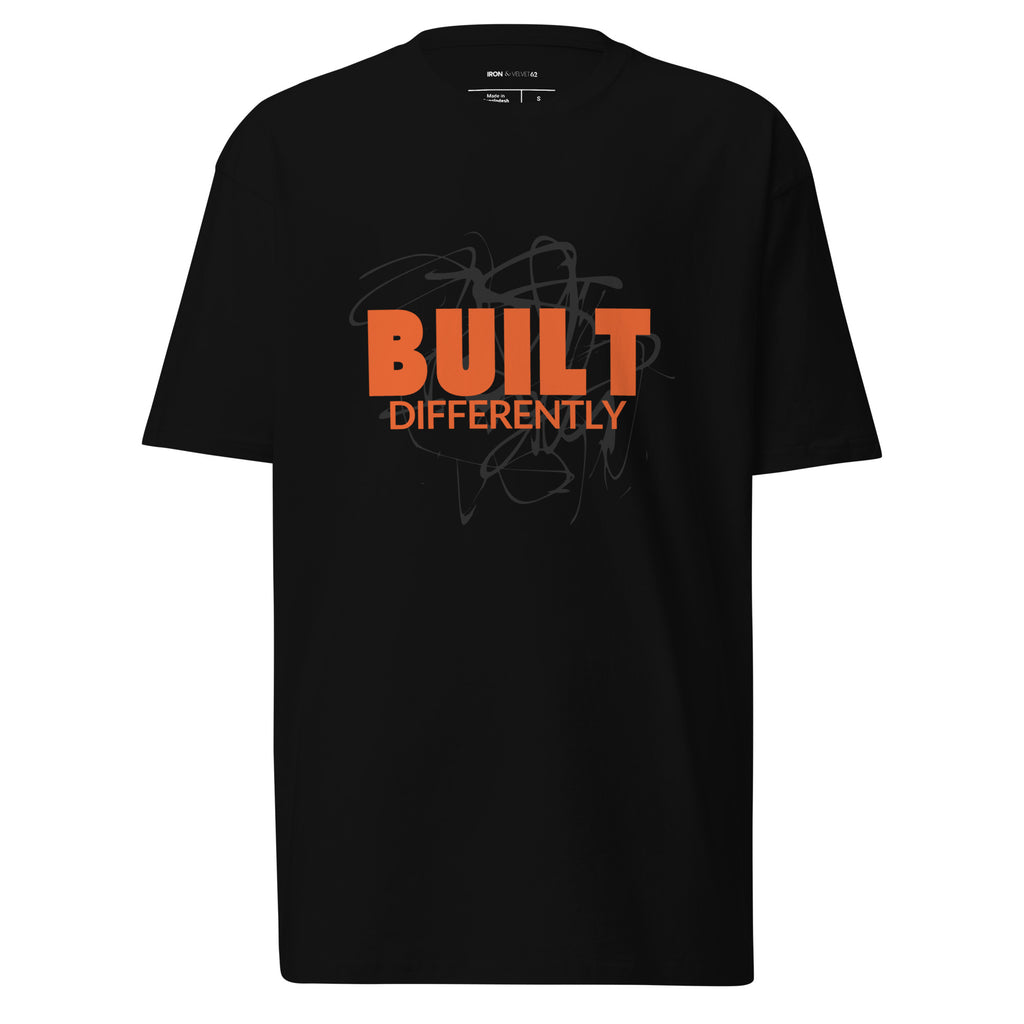mens black color tshirt displayed on a white background with bold orange built differently text and abstract graphic design across the chest modern statement streetwear piece by iron and velvet 62
