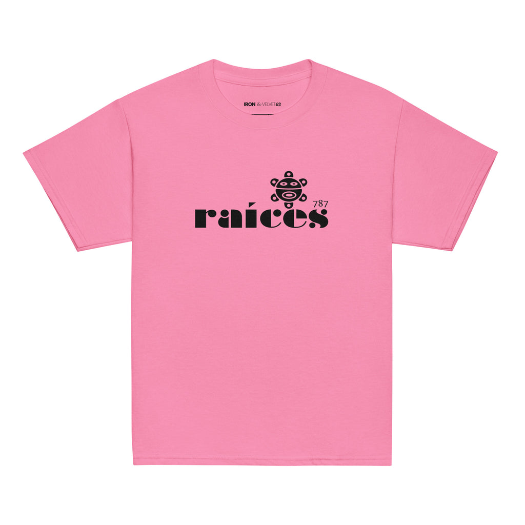 pink raices kids tshirt displayed on a white background with bold black raíces text across the chest  taíno sun and 787 detail, puerto rican cultural design by iron and velvet 62